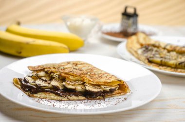 Yulaf unu, muz, çikolata ve fındıklı ev yapımı ince krepler. Sağlıklı yemek, düzgün beslenme kahvaltısı.