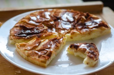 Üstünde tarçın ve bal olan ev yapımı elmalı kek. Bir ısırıkla turta dilimi