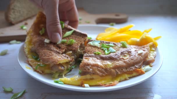 吃一小口煎蛋卷 配上全麦面包 青葱和黄色新鲜生胡椒 早餐吃健康食品 — 图库视频影像