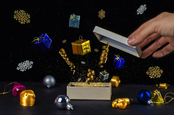 Open Magic Christmas Gift Box with presents, decoration, golden dust, particles, ribbon