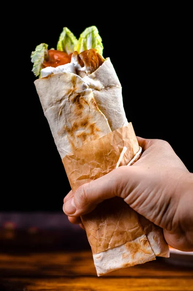 Siyah zemin üzerinde et, sebze ve beyaz soslu Türkçe veya Arapça shawarma