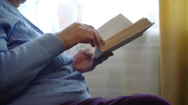 Γριά Κυρία Διαβάζει Ένα Βιβλίο Ενώ Κάθεται Μια Ζεστή Καρέκλα — Αρχείο Βίντεο