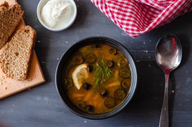 Krema ve ekmekle servis edilen zeytinli, domatesli ve limonlu turşu çorbası. Düzgün beslenme diyeti sağlıklı yiyecekler