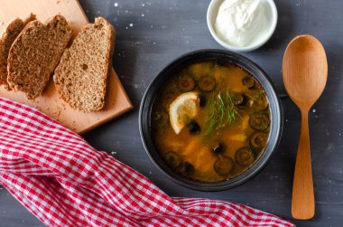 Krema ve ekmekle servis edilen zeytinli, domatesli ve limonlu turşu çorbası. Düzgün beslenme diyeti sağlıklı yiyecekler