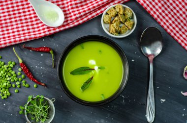 Yeşil bezelye kreması çorbası sağlıklı vejetaryen organik gıda tarifi yanında kızarmış ekmek, garlik ve yeşillik. Ev yapımı geleneksel yemek..