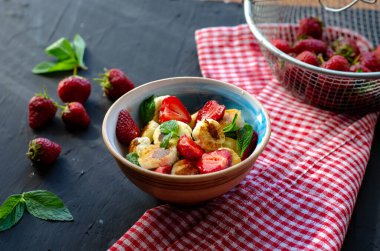 Siyah arka planda bal ve çilekli mini peynir krepleri. Düzgün beslenme sağlıklı tatlı