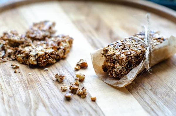 Healthy sweet bars with nuts, sesame, cereals and honey on the rustic wood table background. Proper nutrition. Superfood