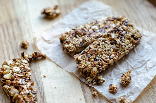 Healthy sweet bars with nuts, sesame, cereals and honey on the rustic wood table background. Proper nutrition. Superfood