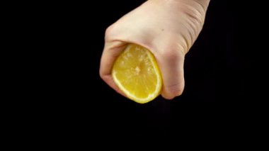 Siyah arka planda sarı olgun limon sıkmak. Limon suyu yapıyorum.