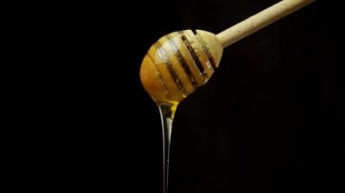 Siyah arka planda şeffaf büyük bardakta sütlü kahvenin içine süt dökerken yavaş çekim. Görüntüyü büyüt