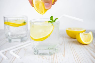 Buzlu ve naneli bir bardak soda ile limon suyu ekleyin. Ferahlatıcı yaz kokteyli konsepti tonik veya şeffaf alkolle