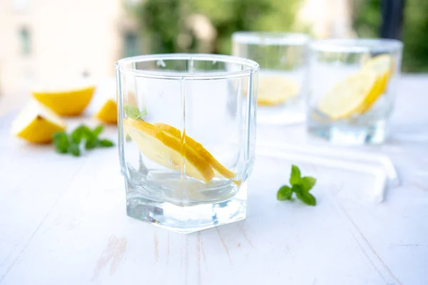 glass of soda water with ice, mint and lemon. refreshing summer cocktail concept with tonic or transparent alcohol