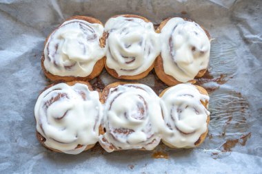 Klasik krem peynirle kaplı taze ev yapımı tarçın ruloları, geleneksel tarçınlı ev yapımı.