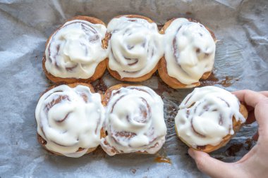 Klasik krem peynirle kaplı taze ev yapımı tarçın ruloları, geleneksel tarçınlı ev yapımı.