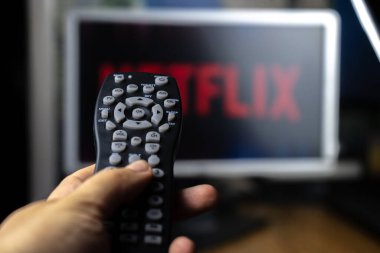 Netflix logolu televizyon ekranının önündeki uzaktan kumanda