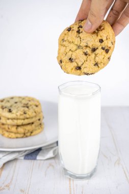Tabakta fındık ve bir bardak sütle taze pişmiş klasik çikolatalı kurabiye.