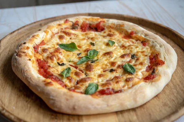 Mozzarella ve fesleğenli klasik pizza margherita, evde pizza yapmak.