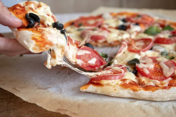 Erimiş peynir ve domatesli ev yapımı bir pizza al.