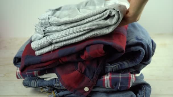 Jeans Pigiama Camicie Che Cadono Sul Tavolo Una Pila Abbigliamento — Video Stock