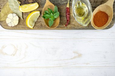 Baharatlı, limonlu, sarımsaklı, yağlı, fesleğenli ve kesme tahtalı bir mutfak. yemek ışığı arkaplanı