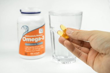 Omega 3 balık yağı büyük jel kapsüller ve bir bardak su, sağlık sigortası, vitaminler