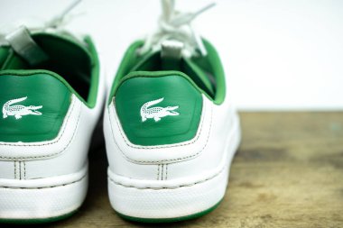 Beyaz ve yeşil ayakkabı bağcıklı Lacoste ayakkabıları. Viyana, Avusturya - Mayıs, 2019