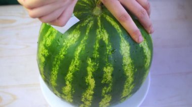 Kadın karpuzu slaytlarla kesti.