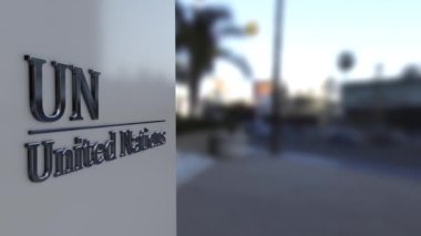 Metal Birleşmiş Milletler amblemi bir binanın ön cephesinde, BM logosu