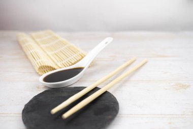 Japon mutfak arka planı bambu hasırı, yemek çubuğu, soya sosu.