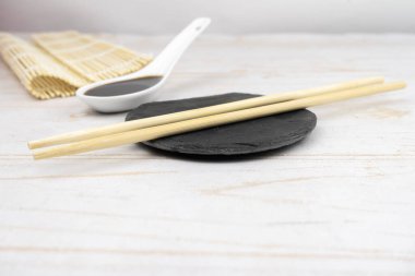 Japon mutfak arka planı bambu hasırı, yemek çubuğu, soya sosu.