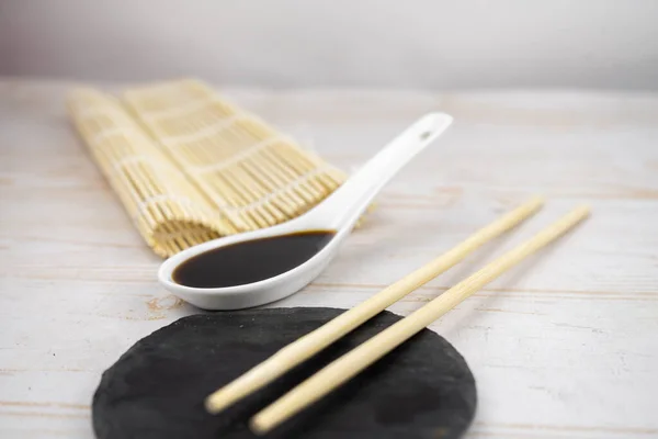 Japanese kitchen background with bamboo mat, chopsticks, soy sauce