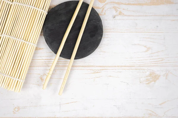 Japanese kitchen background with bamboo mat, chopsticks, soy sauce