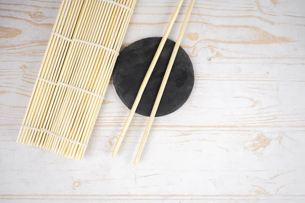 Japanese kitchen background with bamboo mat, chopsticks, soy sauce