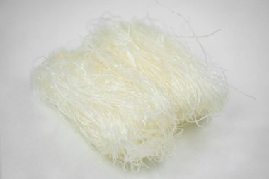 Pişmemiş kuru cam erişte, beyaz fasulye Asya vermicelli, pirinç eriştesi, beyaz üzerine izole edilmiş.