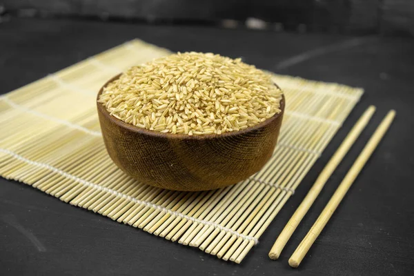 Brown Rice Wooden Bowl Bamboo Mat Asian Kitchen Background Black — Stock Photo, Image