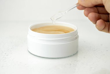 Beyaz bir kapta göz altı bantları, yaşlanma karşıtı cilt bakımı, beyaz ıslak arka plan.