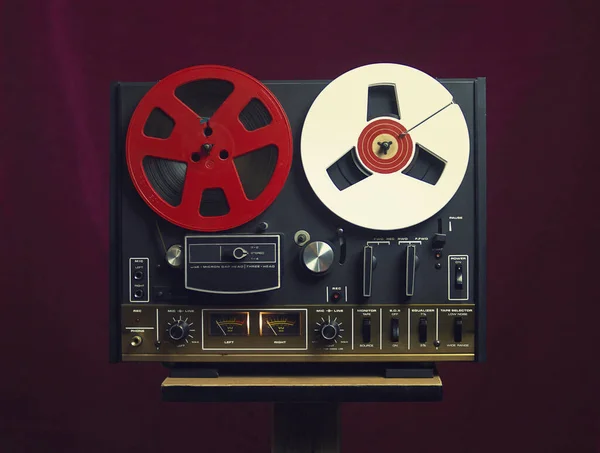 Vintage Reel tape recorder on a red background. A symbol of recording in retro style