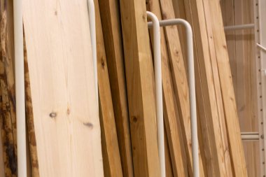 Hırdavatçıdaki tahta panellerin rafı. Ahşap evlerin inşaatını bitirmek. Ahşap, kereste ve tahtalardan yapı malzemesi.