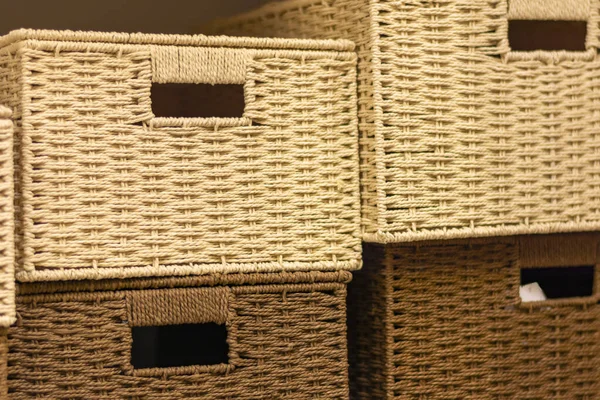 A pile of wicker boxes made of twigs. Light and dark vine in wicker boxes. Interior bathroom for storage. Background and texture of natural vines.