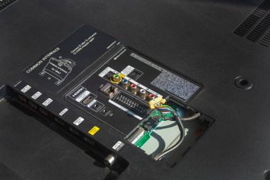 LCD TV 'nin arkası, yakın çekimde televizyonun tamiri. Kabloyla kapağı aç, onarım için hazırlan.