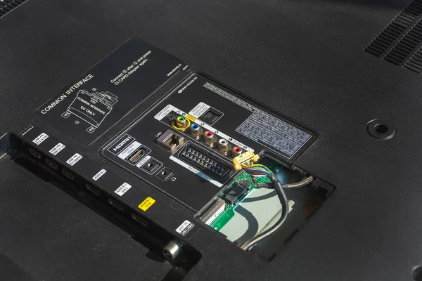 The back of the LCD TV, the repair of the TV on the desktop close-up. Open cover with wire, preparation for repair