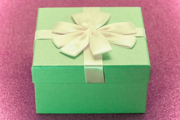 Big gift green box. Close-up. On top of the box is a large bow. Bright background. Birthday Gift Concept.