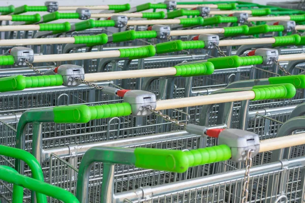 Hipermarkette alışveriş arabaları. Yeşil saplı alışveriş arabaları kilitli.. 