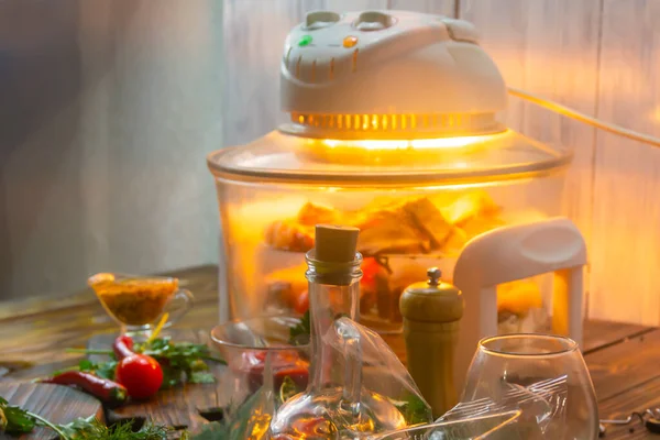 Elektronik konveksiyon fırını, et ızgarası. Lezzetli bir yemek için sebze, baharat ve malzemelerin yanında kızarmış et pişirmek. Seçici odak, yakın plan.