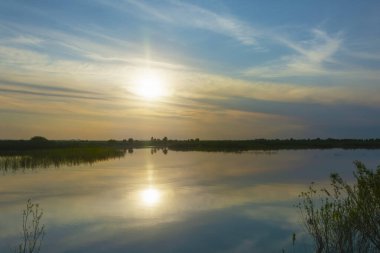 Yaz nehri manzarası, gün batımı, sis manzarası. Güneş ufuktan batıyor.