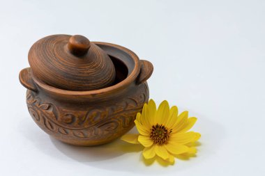 Pişirmek için kil esrar. Hafif arka planda pişirmek için kapaklı kil çömlek. Eski mutfak gereçleri. Sığ alan derinliği.