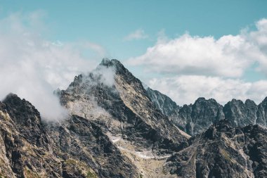 Dağlar oturuyor ve çağlar geçene kadar bekliyor ve yürüyüşçülerin eğlenmesini..