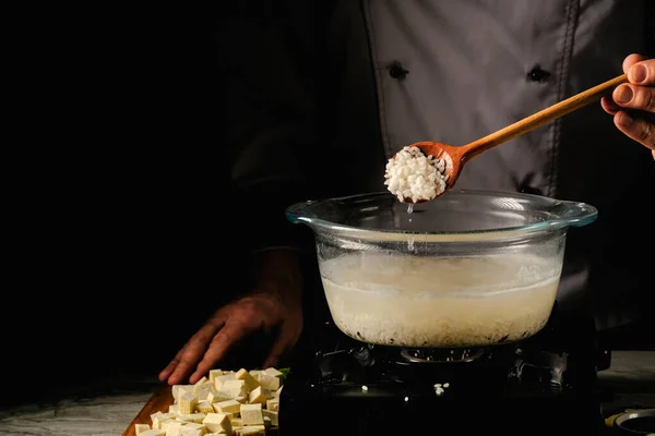 Processo di cottura del riso crudo in un cucchiaio di legno — Foto Stock