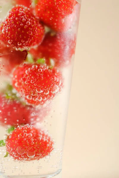Makró izolált koktélüveg vörös szamócával, pezsgő víz összpontosít buborékok — Stock Fotó