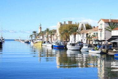 Deniz feneri ve Fransa 'nın Occitanie bölgesinde bir tatil beldesi olan Camargue' deki Grau du Roi 'nin eski balıkçılık limanı.